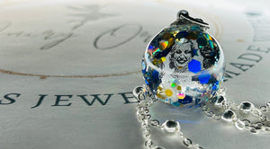 Glass spherical pendant with glitter and personalized treasures such as pictures, names and dates. 