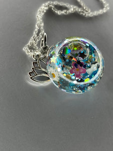 Glass spherical pendant with glitter and personalized treasures such as pictures, names and dates. 